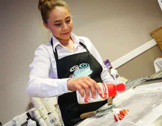 oi making ice cream rolls at a black tie dinner