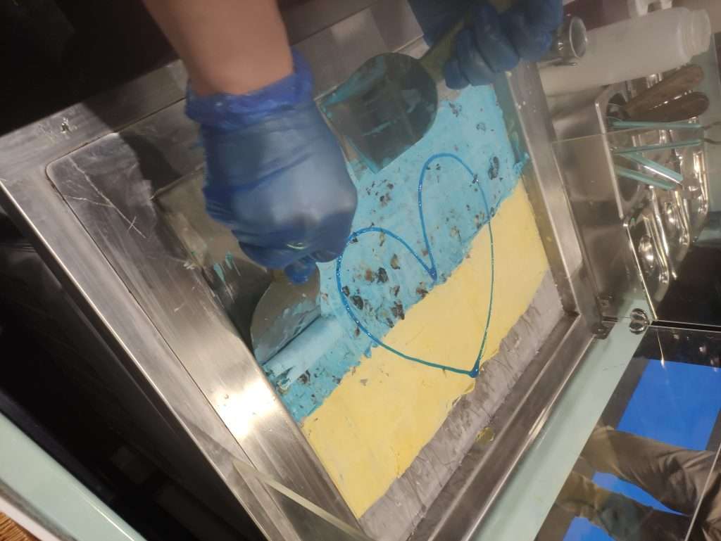 Blueberry and Mango rolled ice cream in style of Ukrainian flag being rolled on ice pan