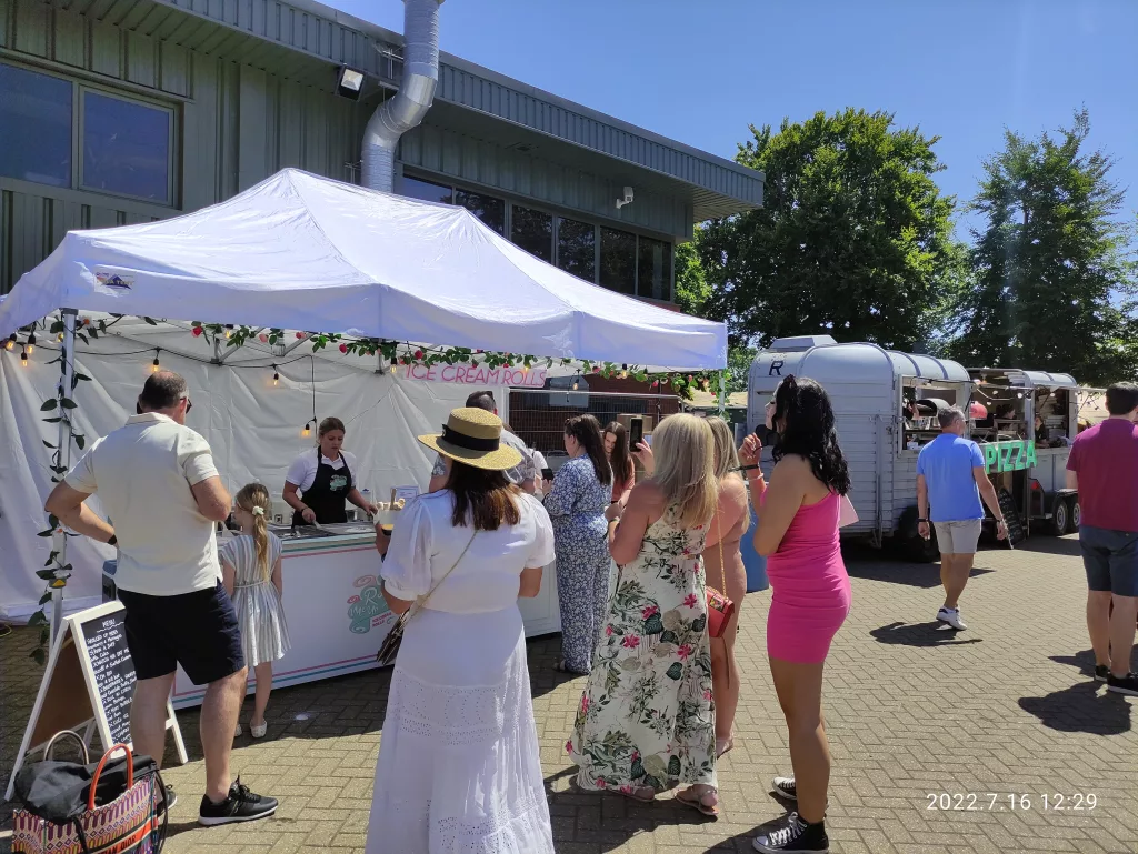 People queuing for ice cream rolls Aston Martin